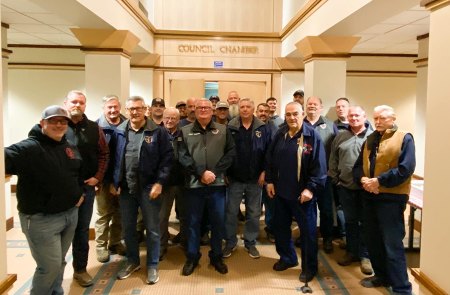 Bruce German, poses with volunteer firemen and past chiefs, in the lobby of the Lemoore City Council Chamber.
